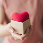 Woman holding giftbox with red heart, love, health insurance, do Woman holding giftbox with red heart, love, health insurance, donation, happy charity volunteer, world mental health day, world heart day, valentine's day
